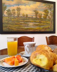 a table with a plate of bread and a glass of orange juice at Floralia Casa Boutique in Bogotá