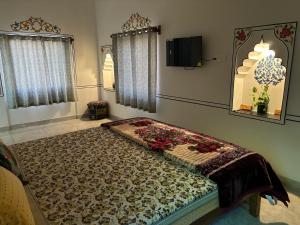 een groot bed in een kamer met een tv aan de muur bij Hotel tulsi palace in Pushkar