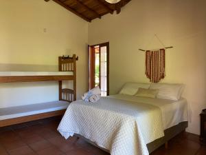 a bedroom with a bed in a room with a window at Pousada Paradise Ferrugem in Garopaba