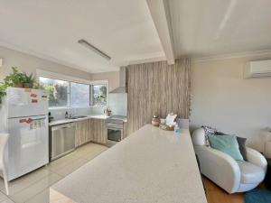 a kitchen with a white refrigerator and a white table at Saltwater Haven - Pets Welcome. Wifi. Amazing View in Apollo Bay