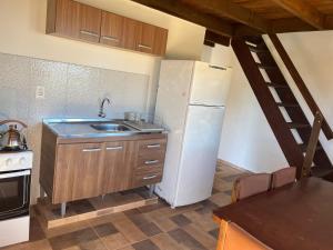 eine Küche mit einem weißen Kühlschrank und einer Spüle in der Unterkunft Hyepy in Punta Del Diablo