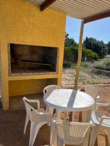 a table and chairs and a fireplace on a patio at Hyepy in Punta Del Diablo