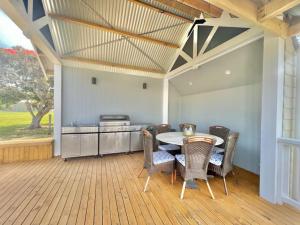 een patio met een tafel en stoelen en een keuken bij Galbraith Beach Studios - Studio 3 in Marengo