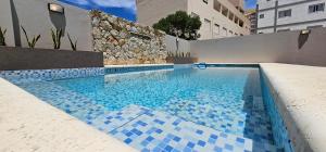 a swimming pool with blue tiles on top of it at Belmar in Villa Gesell