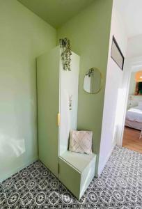 a room with a green wall with a shelf at Nancy Thermal/Gare - Appartement élégant & cosy in Nancy