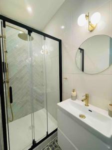 a white bathroom with a shower and a sink at Nancy Thermal/Gare - Appartement élégant & cosy in Nancy