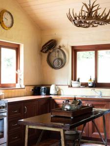 a kitchen with a table and a clock on the wall at Hideaway Cottage - Secluded Retreat - Pet Friendly in Apollo Bay