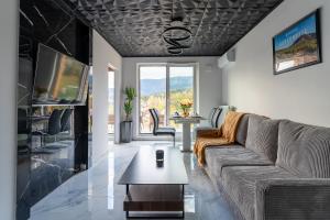 a living room with a couch and a table at Apartament Widokowe Marzenie - blisko stoku, parking podziemny by SpaceApart in Karpacz