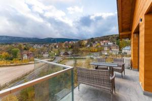 a balcony with two chairs and a table on it at Apartament Widokowe Marzenie - blisko stoku, parking podziemny by SpaceApart in Karpacz