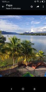 a screenshot of a picture of a lake with palm trees at Hotel y Hostal Mi Reino Represa Prado Tolima in Prado