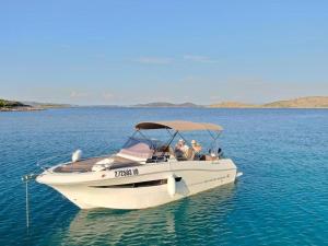 a group of people sitting on a boat in the water at Apartman Centar in Tribunj