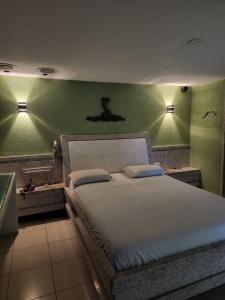 a bedroom with a large bed with green walls at Status Motel PE15 (Adults Only) in Olinda
