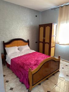 een slaapkamer met een groot bed en een rode deken bij HOTEL NOSTRESS in Khenifra