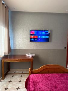 Habitación con cama y TV en la pared. en HOTEL NOSTRESS, en Khenifra