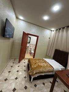 a bedroom with a bed and a mirror and a table at HOTEL NOSTRESS in Khenifra