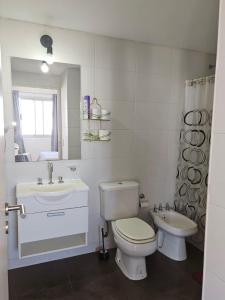 a white bathroom with a toilet and a sink at Apart 1013 con Piscina Gimnasio Laundry y Seguridad 24 hs in Buenos Aires