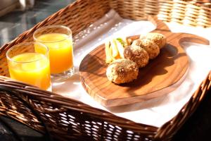a wooden plate with meatballs and french fries and orange juice at Borail Homes in Silchar