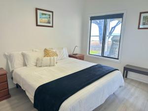 Un dormitorio con una cama grande y una ventana en Seaspray Beach House - Pet Friendly - 50m to Beach, en Apollo Bay