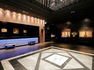 a large room with benches and a brick wall at Hotel Monterey Kyoto in Kyoto