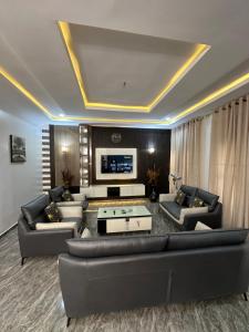 a living room with couches and a flat screen tv at Dabras Homes in Kaduna