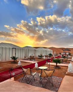 a group of tents in the desert with tables and chairs at Luxury Camp Of Dar Morocco in Merzouga