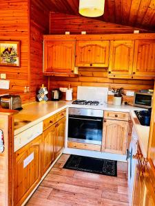 a kitchen with wooden cabinets and a stove top oven at Secluded Rustic Cabin - A Digital Detox Paradise. in York
