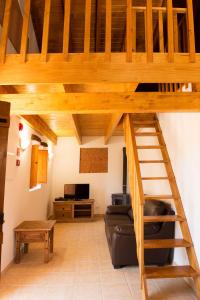 a loft bed in a living room with a couch at Recanto Da Ribeira Casas De Campo in Monchique