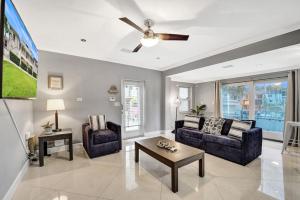 劳德代尔堡Beach Isles Modern 1BR Waterfront Apartment with Patio的客厅配有两张沙发和吊扇