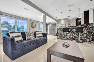 劳德代尔堡Beach Isles Modern 1BR Waterfront Apartment with Patio的客厅里有一张蓝色的沙发和一张桌子