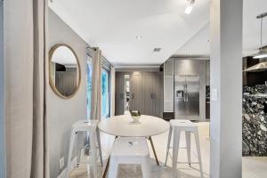 劳德代尔堡Beach Isles Modern 1BR Waterfront Apartment with Patio的一间设有白色桌子和白色凳子的用餐室 更多49张照片