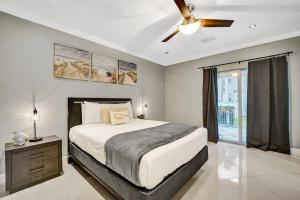 劳德代尔堡Beach Isles Modern 1BR Waterfront Apartment with Patio的一间卧室，里面有一张床和一个吊扇