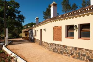 a building with a brick sidewalk next to a wall at Recanto Da Ribeira Casas De Campo in Monchique