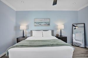 a bedroom with a large white bed with two lamps at Beach Isles Modern 1BR Apartment in Fort Lauderdale in Fort Lauderdale