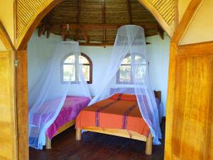 a bedroom with two beds with mosquito nets at Casa Magica in Minca