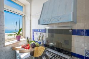 a kitchen with a sink and a stove with a window at Casa Marianna in Praiano +37 photos