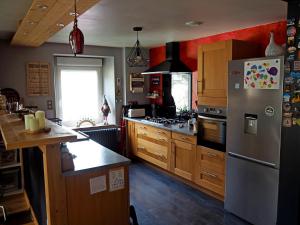 uma cozinha com um frigorífico de aço inoxidável e armários de madeira em Appartement Maison Vosgienne La Bresse Centre em La Bresse