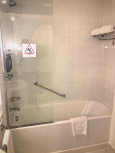 a bathroom with a bath tub with a sign on the glass at Sheraton Sharm Hotel, Resort, Villas & Spa in Sharm El Sheikh