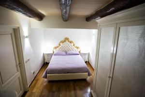 sypialnia z łóżkiem z fioletową narzutą w obiekcie Hause Naty spaccanapoli w mieście Napoli