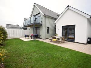 ein weißes Haus mit einer Terrasse und einem Picknicktisch in der Unterkunft 3 bed in Westward Ho 78656 in Northam