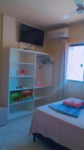 um quarto com uma cama e uma televisão na parede em Pousadas Mafra em Mafra