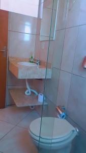 a bathroom with a toilet and a sink at Pousadas Mafra in Mafra