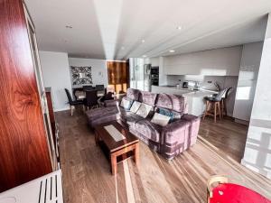 a living room and kitchen with a couch and a table at Piso Camariñas Playa de Area in Camariñas
