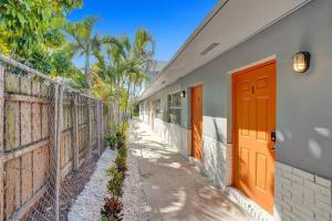 un bâtiment avec des portes orange et une clôture dans l'établissement Pionciana Getaway 1BR Apartment Near FLL Airport, à Fort Lauderdale