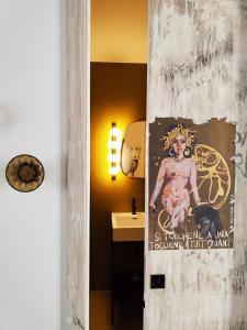 een badkamer met een poster aan de muur naast een wastafel bij Magma Home - Rooms & Roof in Napels