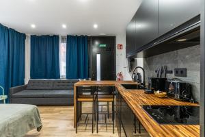 VR LATINA APARTMENTS في مدريد: مطبخ وغرفة معيشة مع كونتر وأريكة