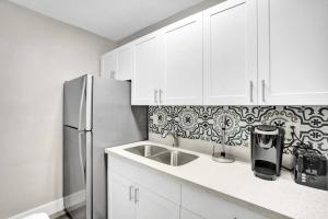 a kitchen with white cabinets and a refrigerator at Pionciana Getaway 1BR Apartment Near FLL Airport in Fort Lauderdale
