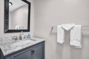 a bathroom with a sink and a mirror and towels at Pionciana Getaway 2BR Apartment Near FLL Airport in Fort Lauderdale