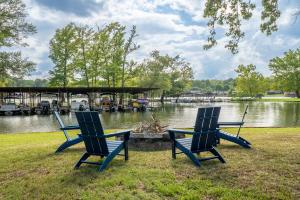 twee blauwe stoelen in het gras bij een meer bij Stunning Luxury Lakefront Lodge! 8 BRs! Sleeps 32! in Hot Springs