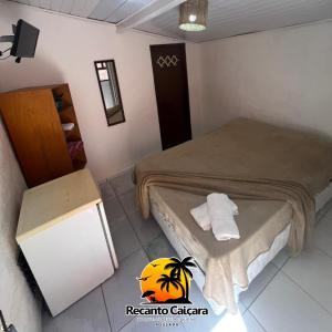 um quarto de hotel com uma cama e um frigorífico em Pousada Recanto Caiçara em São Sebastião