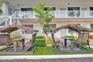 two chairs and a table in front of a building at Waves Beach Town Studio Apartment in Pompano Beach +8 photos